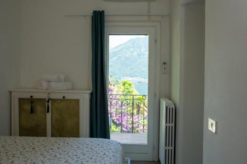 a bedroom with a bed and a window with a view at Emy House Charming Apt Stunning Views Balcony AC in Carate Urio