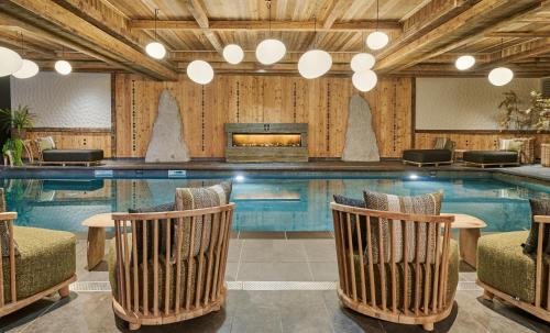 a pool with chairs and a table in front of it at Les Suites – Maison Bouvier in Tignes