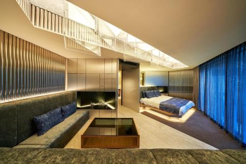 a hotel room with a couch and a bed at The Blue House in Katsuura