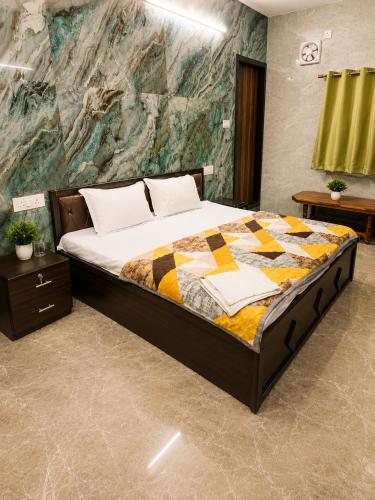 a bedroom with a bed with a quilt on it at Shri Shyam Kunj Hotel in Ambikāpur
