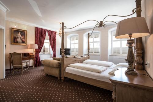 a bedroom with a bed and a desk with a lamp at Meiser Altstadt Hotel in Dinkelsbühl