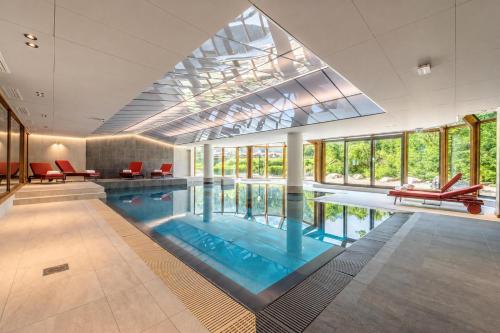 a swimming pool with red chairs in a large building at Résidence Le Cristal Apartments in Chamonix