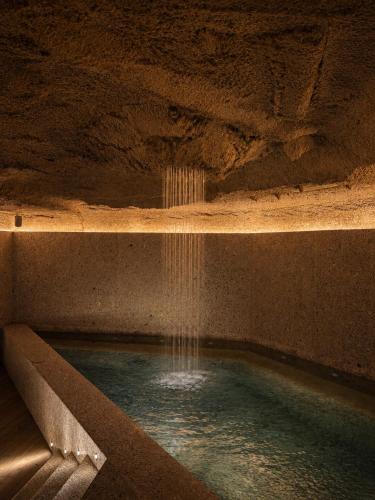 a swimming pool with a waterfall in a cave at Mercer Madrid in Madrid