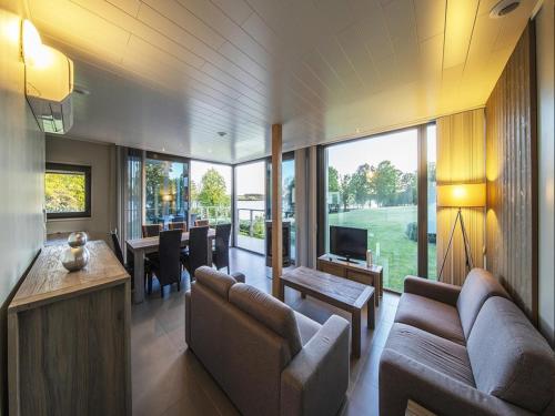 a living room with a couch and a dining room at Lakeside Stay with Sauna in Boussu-lez-Walcourt