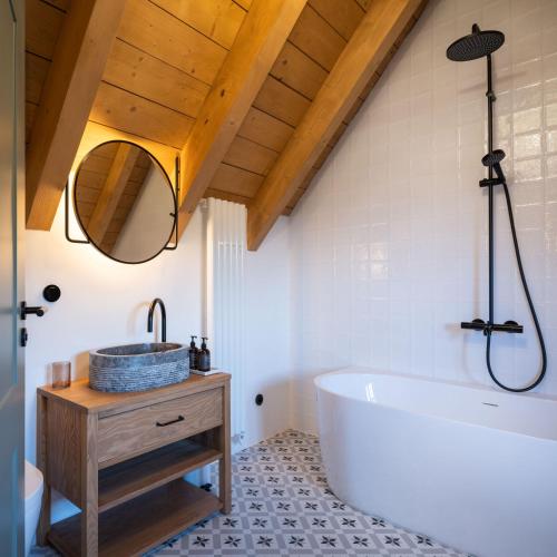 a bathroom with a large tub and a sink at Šimuntov dvor in Nová Baňa