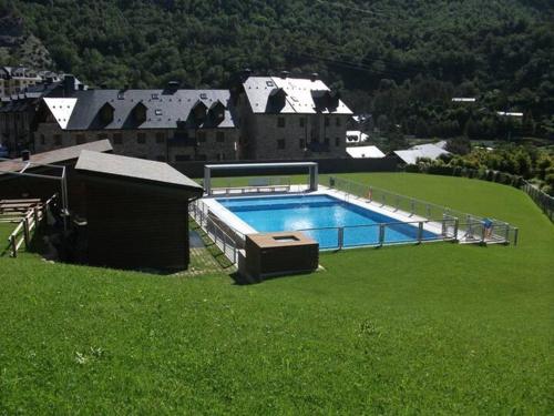 a large swimming pool in a field of green grass at Ibón de tebarray in Escarrilla