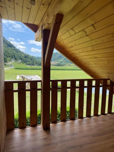 a wooden porch with a view of a green field at Martinova izba - Family Bungalows in Laško