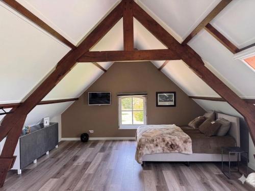 a bedroom with a bed in a attic at Het Atelier Schuring - Luxe vakantiehuis 78m2 in Numansdorp