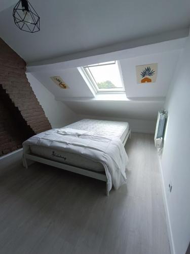 a bedroom with a bed in a room with a window at La Courée d'Orchies in Loos