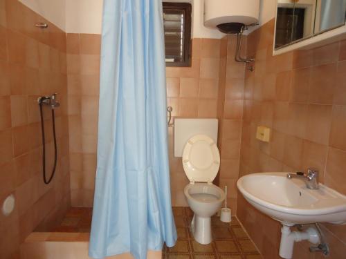 ein Badezimmer mit Toilette und Waschbecken in der Unterkunft Apartments Vrša in Seline