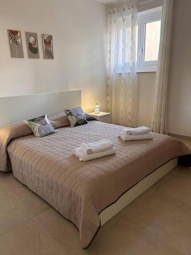 a bedroom with a large bed with towels on it at 'Na Scalunera in Mezzojuso