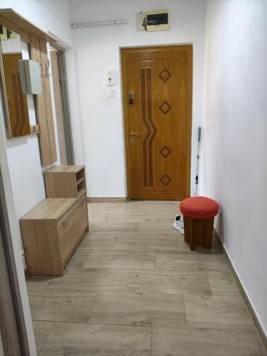 a hallway with a wooden door and a red stool at Intime Poto House Suceava in Suceava