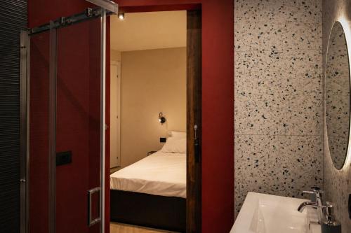a bedroom with a bed and a bathroom with a mirror at L'ateneo Lumiére in Agrigento