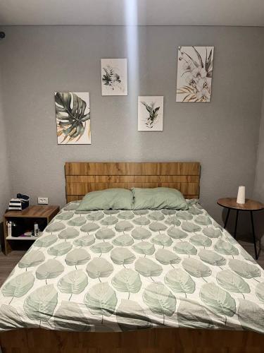 a bed in a bedroom with paintings on the wall at FishKa in Cholpon-Ata