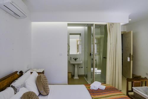 a bedroom with a bed and a bathroom with a sink at Casa Matriz Séc. XVI | Double or Twin w/ balcony in Penafiel