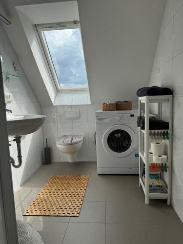 a bathroom with a washing machine and a window at Gemütliche Maisonette nahe Dinkelsbühl in Schopfloch