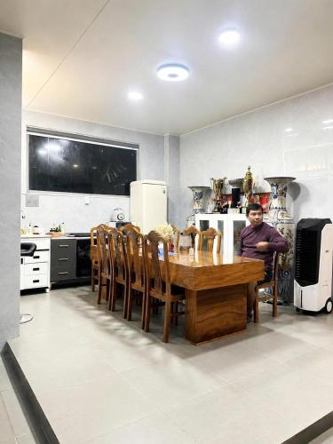 a man sitting at a table in a kitchen at Happy House Sài Gòn in Ho Chi Minh City