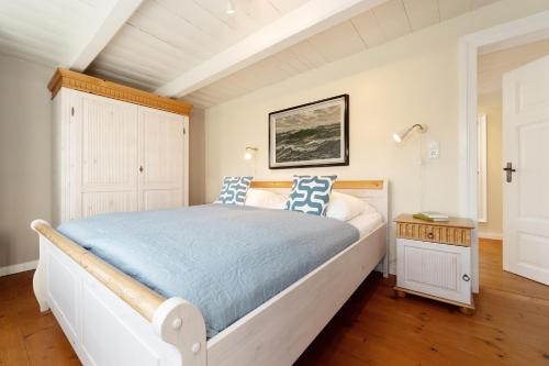 a bedroom with a large bed with blue and white pillows at Fischerhaus in Fehmarn