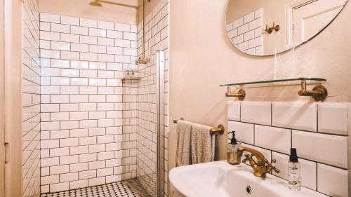 a white bathroom with a sink and a mirror at Onse Rus Guesthouse in Prince Albert