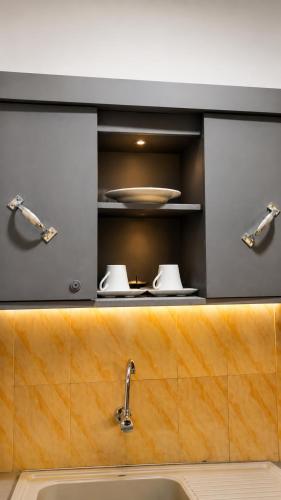 a kitchen with a sink and a shelf with dishes at MANDJOU résidence in Abidjan