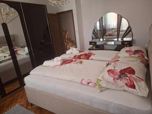 a bedroom with two beds and a mirror at Kuća Latice in Tomislavgrad