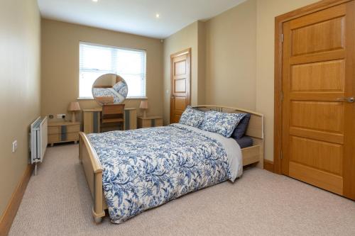 a bedroom with a bed and a table and a window at Copperbeech Farm Guest House in Moira