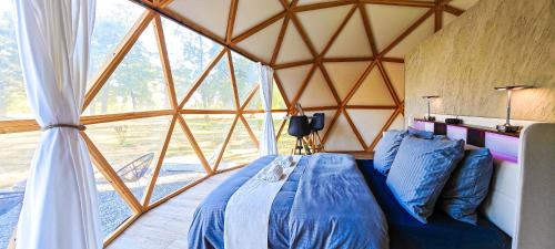 a room with a bed and a large window at Dôme Diem luxe climatisé in Lesterps