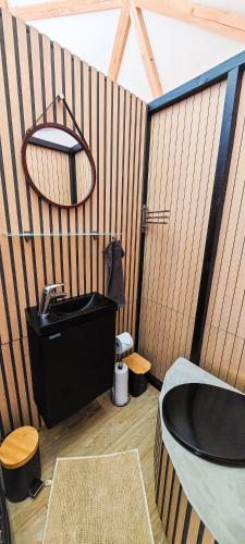a bathroom with a black tub and a sink at Dôme Diem luxe climatisé in Lesterps