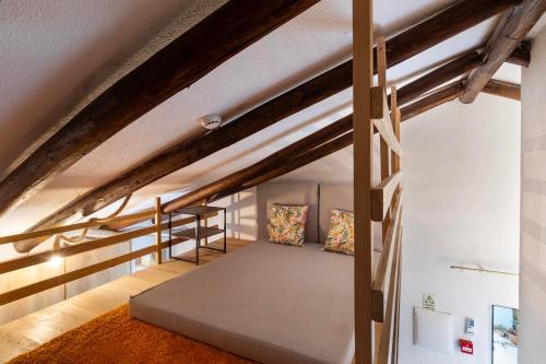 a loft bed in a room with wooden beams at Penedo Escape Nature in Colares