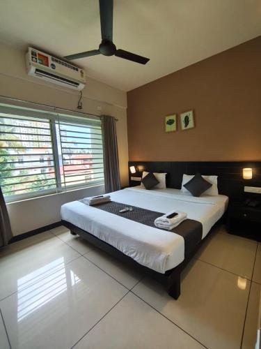 a bedroom with a large bed with a ceiling fan at IVY RESIDENCY in Trivandrum