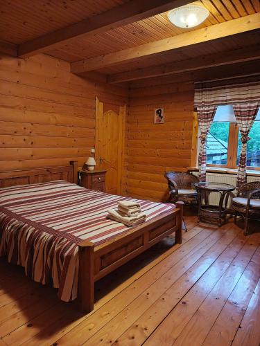a bedroom with a bed in a log cabin at Stara Khata Карпати in Sheshory