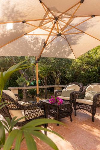 a patio with chairs and a table with an umbrella at Casa Tramonto I Peaceful Family House with garden, Veli Lošinj in Veli Lošinj