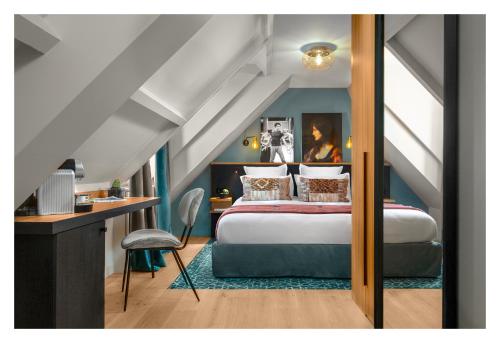 a bedroom with a bed and a desk in a attic at Lyric Hotel Paris Opera in Paris