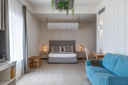 a living room with a bed and a blue couch at Regiohotel Manfredi in Manfredonia