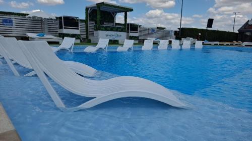 a group of white chairs in a swimming pool at Grand Hotel Residence Pieštany Adult only Boutique hotel Next to Wake Soul Beach in Piešťany