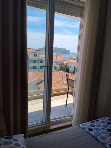 a bedroom with a large window with a view at Apartman Vesna in Budva