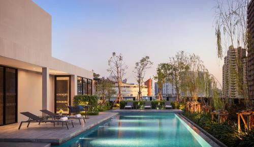 a swimming pool in the middle of a building at Walton Suites Sukhumvit in Bangkok