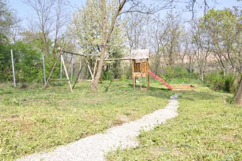 a playground in a field with a swing at Gloriett Panzió in Fertőboz
