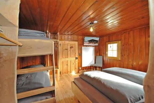 a bedroom with bunk beds in a wooden cabin at Ferienhof Holzmeister in Sankt Jakob in Haus