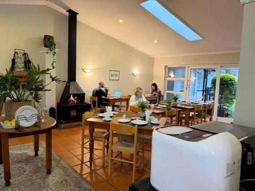 a restaurant with people sitting at tables and a fireplace at Somer Place B&B in Somerset West