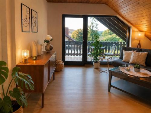 a living room with a couch and a table at Odw homes - naturnahe Wohnung im Landhaus in Trösel