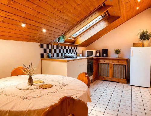 a kitchen with a table and a white refrigerator at Odw homes - naturnahe Wohnung im Landhaus in Trösel