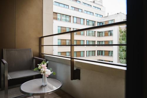 a vase of flowers on a table in front of a building at Mandarin Oriental, Paris in Paris