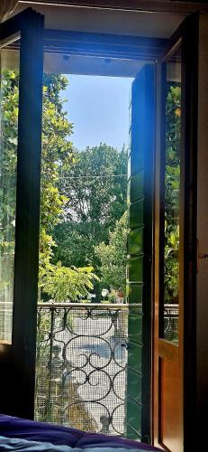 a window with a view of a garden from a balcony at Antica Dimora Confine in Mira