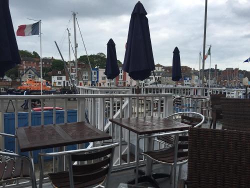 two tables and chairs on the deck of a marina at The Chatsworth in Weymouth
