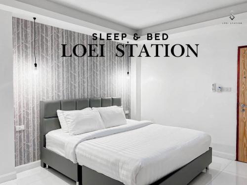 a bed in a white room with a sign that reads sleep and bed lost station at Loei Station in Loei