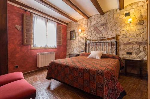 a bedroom with a bed and a stone wall at Hotel Apartamentos Melihah in Daroca