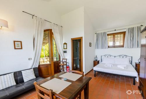a living room with a bed and a table at PoloTuristicoUmbria Rustico con Piscina Vista Lago in Passignano sul Trasimeno