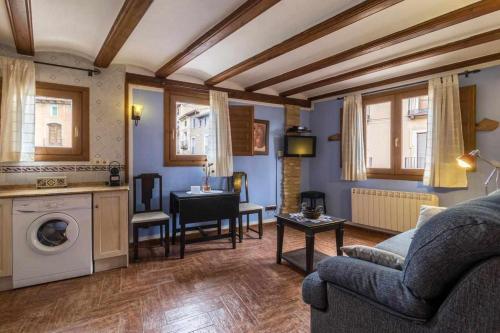 a living room with a couch and a table and a kitchen at Hotel Apartamentos Melihah in Daroca