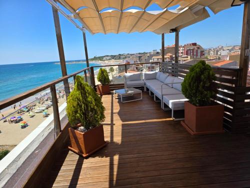 a balcony with a couch and a view of the beach at Apartamentos Wundermar in Torredembarra